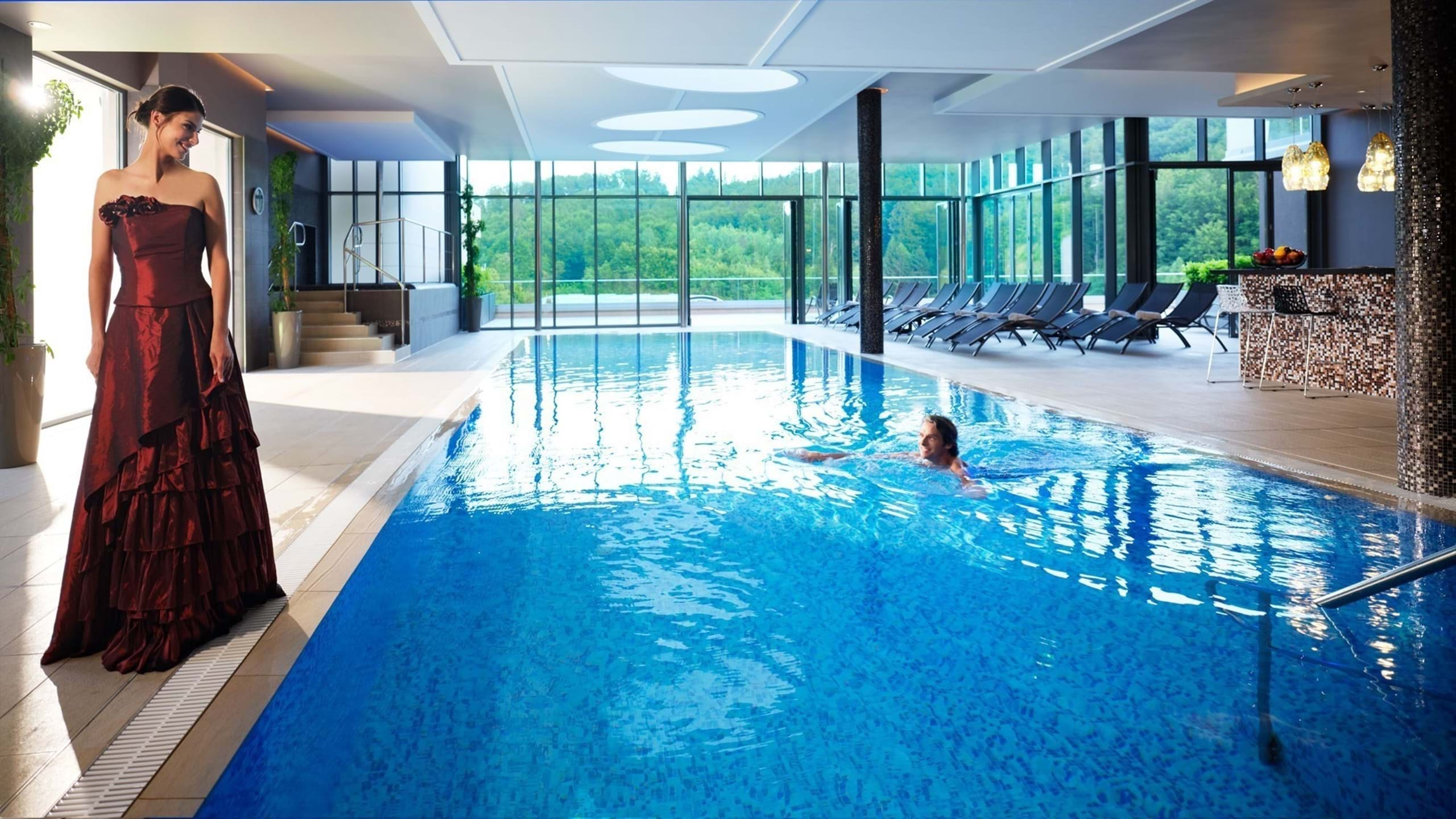 Frau im Abendkleid am Pool