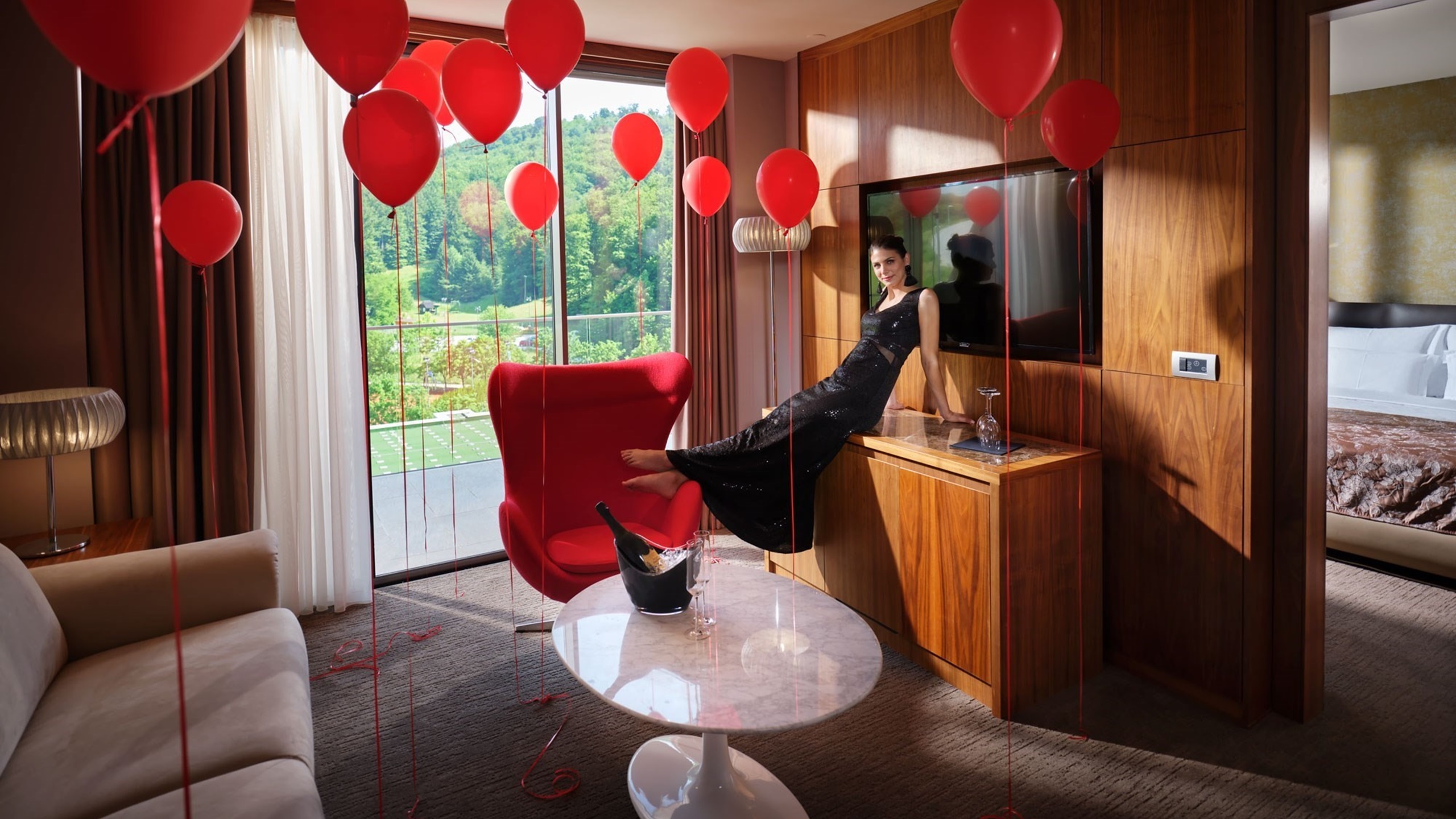 a woman fills red balloons in a hotel room